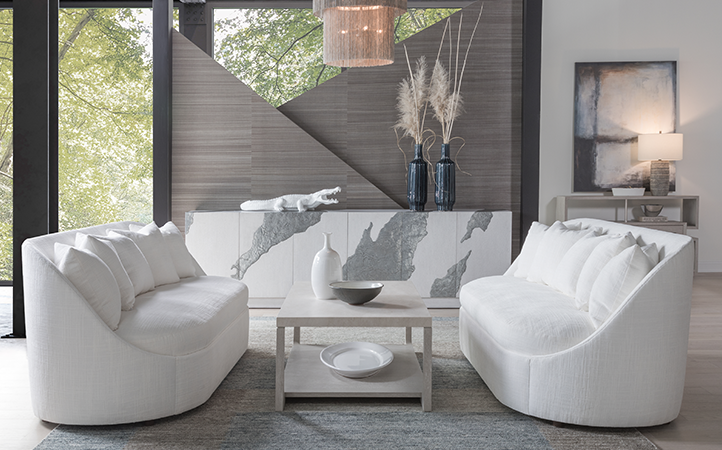 Artistica Upholstery scene featuring two sofas, a long console, bookshelf, and a cocktail table.