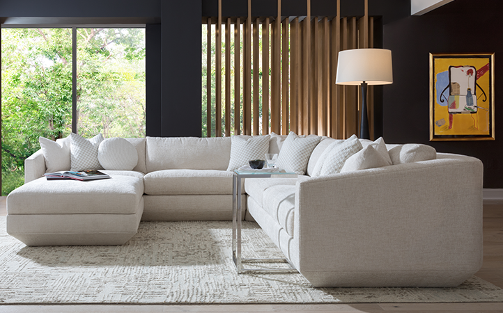 Artistica Upholstery scene featuring a white sectional, and a silver and clear top side table.