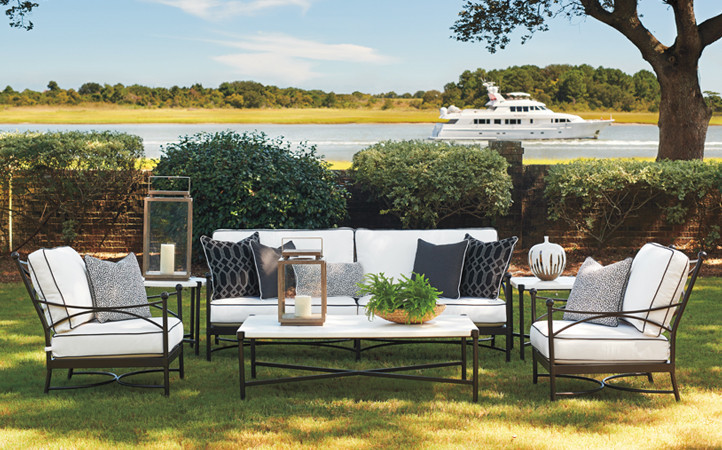 Outdoor Setting with white and black sofa and chairs. Boat in the Background