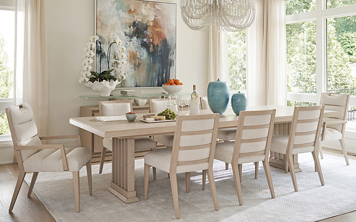 Sunset Key dining room scene featuring long dining table with side and arm chairs.