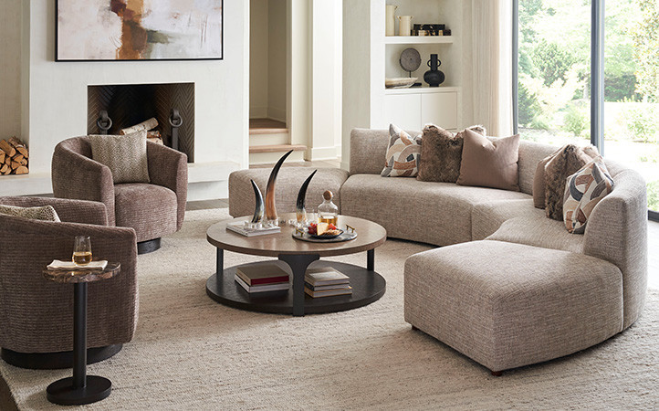 The Kenya cocktail table features a radial veneer pattern on the top, a base in the dark Tunis finish and custom flared metal supports.